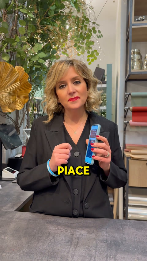 Miriam nella bottega di Creazioni di Miriam a Vercelli, con lo smartphone in mano